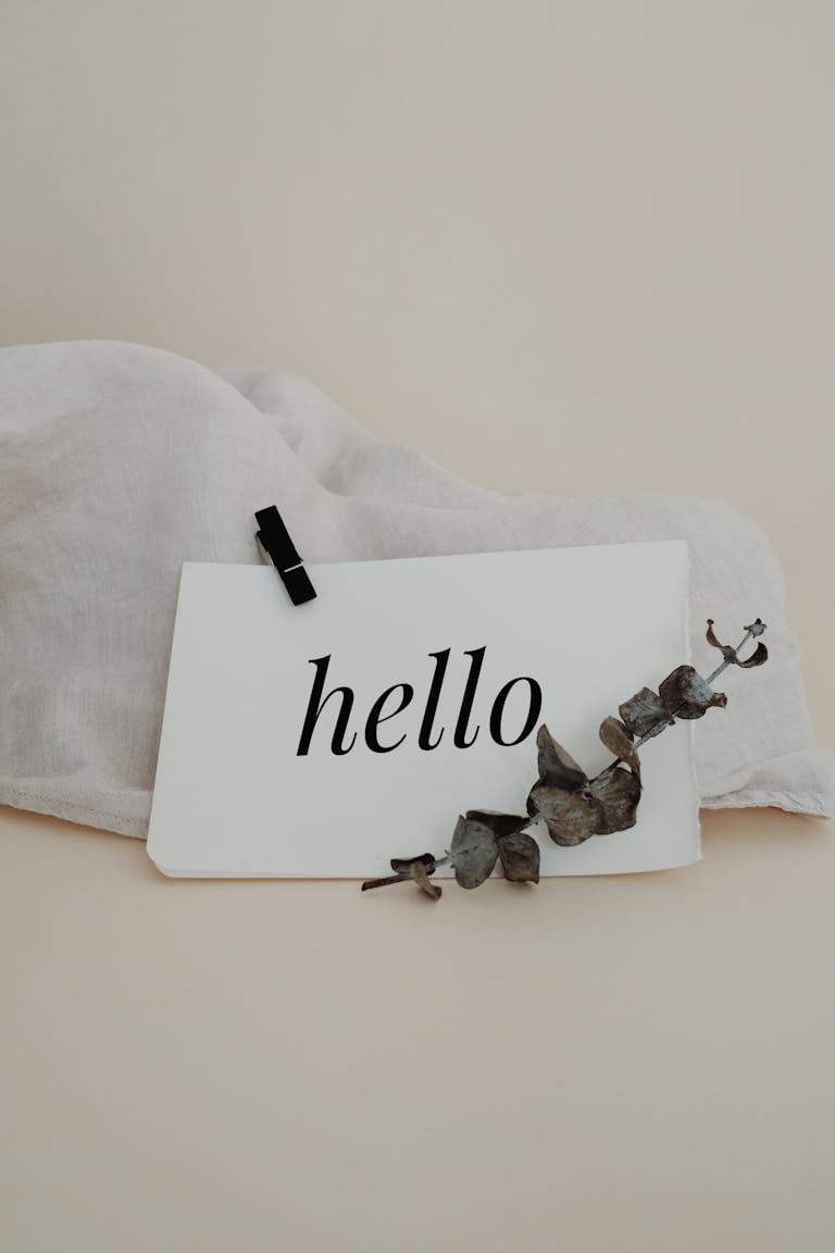 A simple greeting card with 'hello' text, adorned with dried eucalyptus leaves. Perfect for invitations.